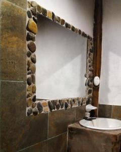 明多Cinnamon House的浴室的墙上设有一面镜子和岩石