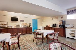 伍德斯托克伍德斯托克豪生酒店的一间带桌椅的用餐室和一间厨房