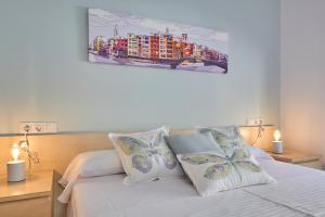 赫罗纳Little Home Girona的一间卧室配有带白色床单和枕头的床。