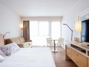 圣特罗让莱班塔拉萨欧勒龙岛诺富特酒店的酒店客房设有床和客厅。