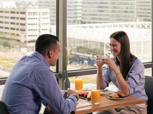 阿姆斯特丹阿姆斯特丹斯劳特戴克站美居酒店的坐在桌子旁喝橙汁的男人和女人