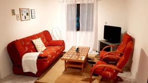 HolčíkovceChata Domaša - Monika的客厅配有红色的沙发和桌子