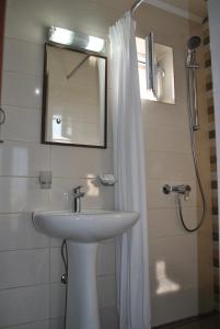 旧瓦马Vila Amir的一间带水槽、镜子和淋浴的浴室