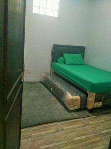 万隆Homestay Bumi Asri III Cikutra的一间卧室,配有一张由木头制成的床