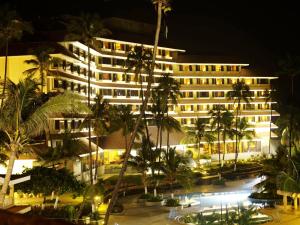 孟买隐逸酒店及会议中心的棕榈树的夜间酒店景色