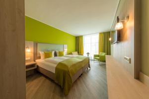 诺德奈Michels Inselhotel Vier Jahreszeiten的酒店客房,设有床铺和绿色的墙壁