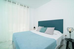 瓦伦西亚Flatsforyou Ruzafa的一间卧室配有一张大床和蓝色床头板