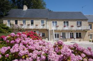 Sainte-Honorine-des-Pertes乐克洛斯圣让住宿加早餐旅馆的前面有粉红色花的房子