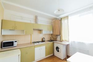 苏梅Apartments Faraon的厨房配有黄色橱柜、洗衣机和烘干机