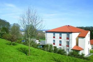 因弗内斯因弗内斯青年旅舍的绿色山丘上一座白色的建筑,屋顶橙色