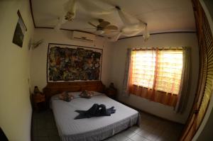 马埃岛博竹公寓的一间卧室,配有一张床,上面有帽子