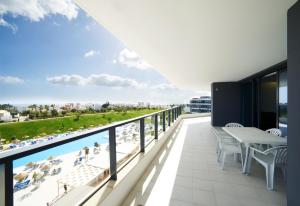 阿尔沃尔RR Alvor Baía Resort的阳台享有游泳池和海滩的景致。