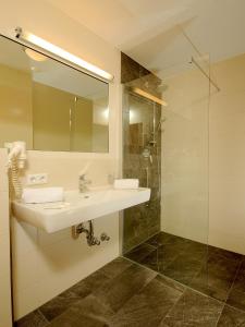 图克斯博格斯克芬酒店的一间带水槽和玻璃淋浴的浴室