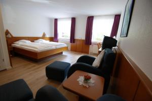 巴特贝特里希Bertricher Hof的酒店客房配有一张床、一张沙发和椅子。