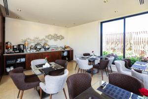 安曼库塔尔公寓的餐厅设有桌椅和大窗户。