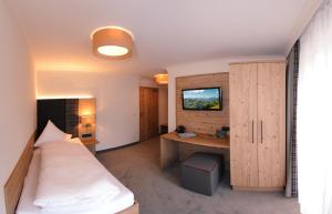 萨尔巴赫贝肯霍夫酒店的客房设有一张床和一张带显示器的书桌