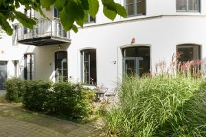 汉堡Das kleine Grindel的带阳台和植物的白色房屋