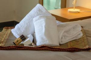 佩特拉利亚索普拉纳Antico Resort Cerasella的床上的一大堆毛巾和洗浴用品