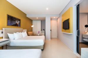巴兰基亚Crowne Plaza Barranquilla, an IHG Hotel的一间酒店客房,配有一张床和一台电视