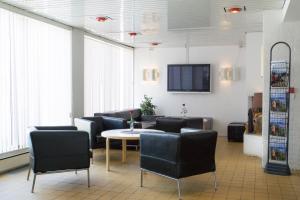 GlomfjordGlomfjord Hotel的一间设有椅子和桌子的等候室以及一台电视