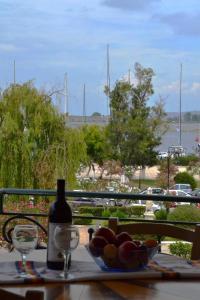 雷夫卡达镇Prokimea Seaview Apartments的一张桌子,上面放着一碗水果和一瓶葡萄酒