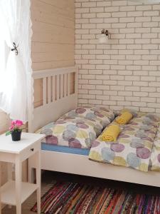 博加奇Apartamenty przy winnicach的卧室配有床和白色砖墙