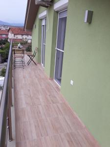 盖夫盖利亚Vila & Apartments MATEA的阳台拥有绿色的墙壁和木地板。