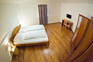 维斯普雷姆野生葡萄酒店的一间卧室配有一张床,铺有木地板