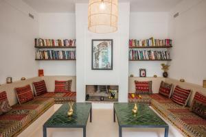 马拉喀什Riad Alia的带沙发和书架的客厅