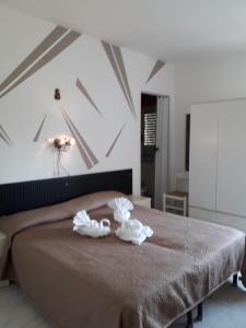 吉泽里亚Hotel Santa Caterina的一间卧室配有一张床,上面有两条毛巾