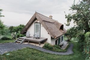 巴拉通尤洛克Noemi's Cottage的茅草屋顶和长凳的小房子