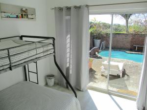 钦查Cintsa View的一间卧室配有一张双层床,享有游泳池的景色