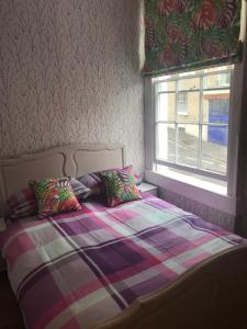 巴斯Central city pad one bedroom plus double sofabed的一张带两个枕头的床和一个窗户