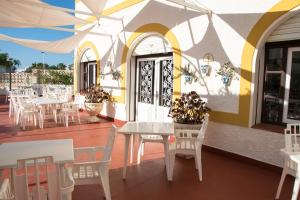 圣何塞Pension Agadir的一间在甲板上配有白色桌椅的餐厅