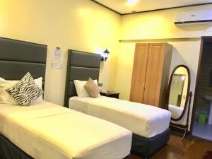 独鲁万吉臣酒店的酒店客房,设有两张床和镜子
