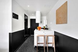 奥斯陆奥斯陆福诺公寓式酒店的厨房拥有黑白墙壁和桌椅