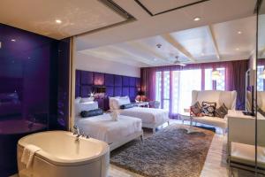 曼谷Hua Chang Heritage Hotel的酒店客房设有两张床和浴缸。