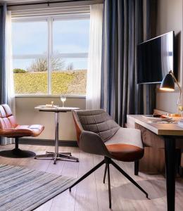 戈尔韦海港酒店的客房设有书桌、椅子、桌子和窗户。