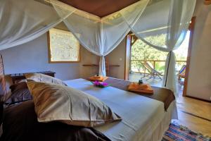 Nosy KombaCoco Komba Lodge的卧室配有带枕头的床铺和窗户。