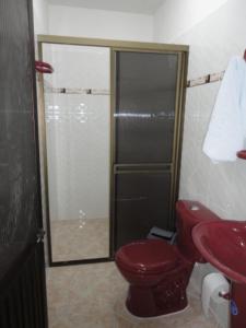 MitúHotel Los Paisas的一间带红色卫生间和淋浴的浴室