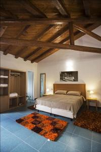 佩特拉利亚索普拉纳Antico Resort Cerasella的一间带一张床的卧室,位于带木制天花板的房间内