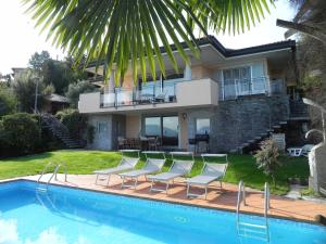 梅纳Villa Diamante的一座房子,里面设有游泳池、椅子和一座房子