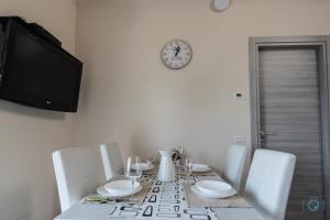 奥杰比奥Home Sweet Home Lakeview的餐桌、白色椅子和时钟
