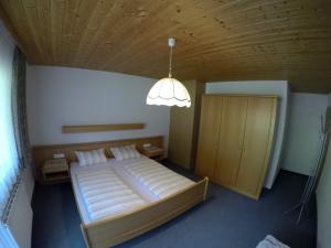 坦海姆Gastehaus Reichle的一间卧室配有一张大床和一盏灯