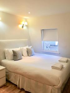 伦敦百乐门酒店的卧室配有一张大白色床和窗户
