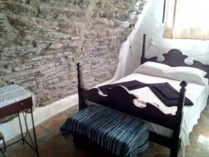 ArnadosTerra Aeolica的一间卧室设有一张床和石墙