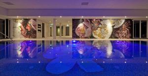 施皮尔施皮尔温格路凡德瓦克酒店的一间设有游泳池的客房,墙上挂有绘画作品