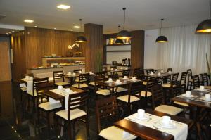 Marechal Cândido RondonHospedare Hotel的用餐室配有木桌和椅子