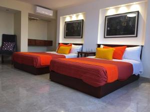 圣路易斯波托西圣露西亚博斯克酒店的配有橙色和黄色枕头的酒店客房的两张床