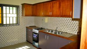 洛美Villa Beach Avepozo Lome的厨房配有木制橱柜、炉灶和水槽。